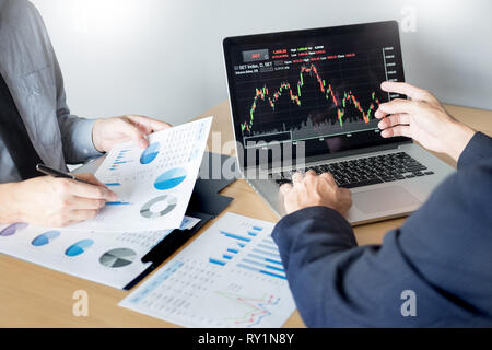 Die Unternehmer sprechen über Börse investieren Trading online Analyse ueber finanzielle Graph für Investitionszwecke Diskussion im Traders Büro Stockfoto