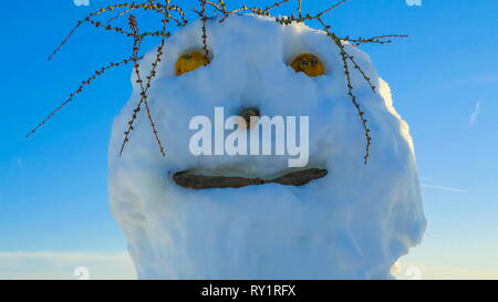 Sehen sie die hässliche Schneemann mit Zweigen auf seinen Kopf, große Augen und Nase Stockfoto