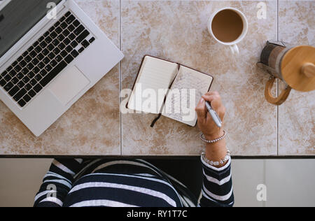Blick von oben auf die Reife womans Arbeit Raum zu Hause. Ältere Frau, die Sie in Ihrem Notebook von Zuhause aus arbeiten mit Laptop Stockfoto