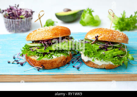 Grün Burger mit Avocado, Gurke, Frischkäse und Micro Grüns auf ein Blue Board Stockfoto