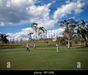 Australien. New South Wales. Snowy Mountains. Cooma Golfplatz. Zwei Männer auf Putting Green. Stockfoto
