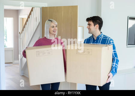 Junges Paar Kisten in die neue Heimat am Umzugstag Stockfoto