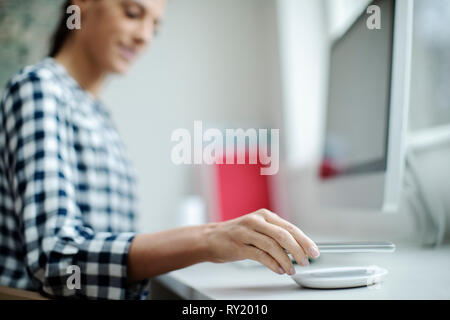Geschäftsfrau, Arbeiten am Computer drahtlos Aufladen Handy Stockfoto