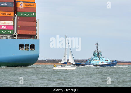 Das kleine Segelboot, DRIFTER, verläuft in der Nähe der riesigen Containerschiff, MOL TRIBUT, wie es in den Hafen von Southampton nach einem 26-tägige. Stockfoto