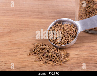 Nahaufnahme der Kümmel und Messlöffel auf einem Holztisch mit Kopie Raum Stockfoto