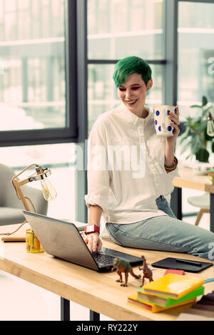 Gerne Frau sitzt auf dem Tisch begeistert Stockfoto