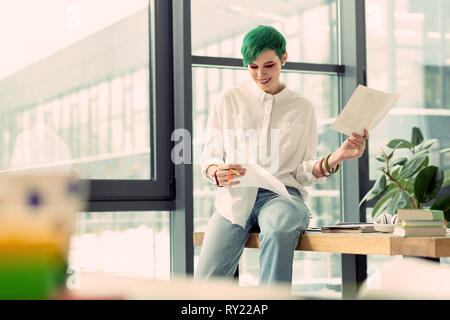 Positive attraktive junge Frau die Wahl zwischen Zeichnungen Stockfoto