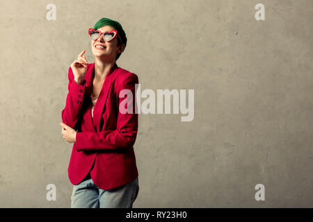 Positive fröhliche Frau trägt eine rote Jacke Stockfoto