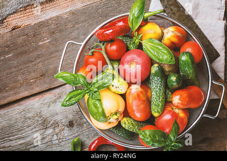 Frisches Gemüse aus dem Garten in Metall Korb über rustikal Hintergrund, Ansicht von oben Stockfoto