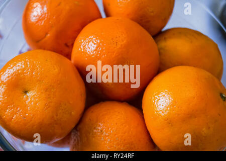 Frische Mandarinen in Weiß Glasschale close-up Stockfoto