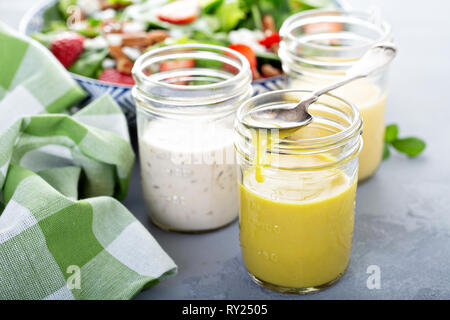 Vielzahl von Salatdressings, die in Gläsern Stockfoto