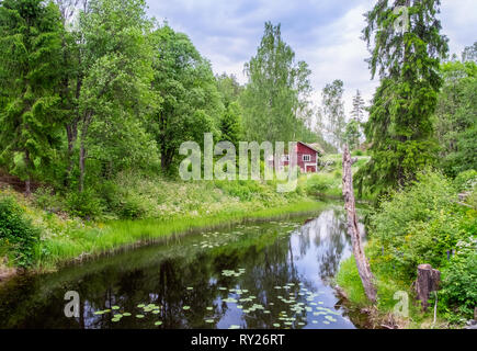 Idyllischen Fluss mit alten, verlassenen Hütte und grünen üppigen Bäumen im Sommer Tag in Finnland