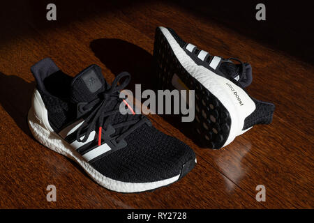 Schwarz Adidas Laufschuhe Ultraboost auf Parkett Stockfoto