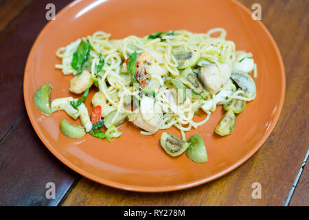 Frische heiße Thailändisches Grünes Curry Sauce Spaghetti mit Fisch, Garnelen, Aubergine und Heiliges Basilikum Blätter. Traditionelle Thai Seafood Küche. Stockfoto