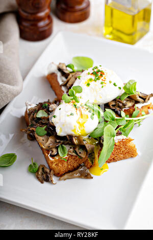 Frühstück Toast mit Pilzen und pochierte Eier Stockfoto