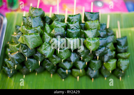 Frisch zubereitete asiatische Betelblatt wraps serviert am Spieß. Traditionelle thailändische Küche aus frischen Zutaten. Stockfoto