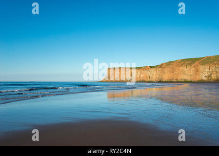 Strand bei Saltburn-by-the-Sea an der Küste von North Yorkshire, England. Blick auf die hohen Klippen von Huntcliff. Stockfoto