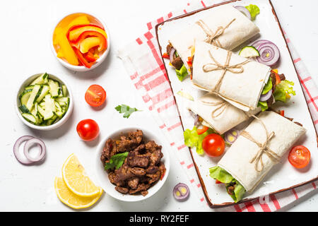 Burritos Tortilla Wraps mit Rindfleisch und Gemüse auf Weiß. Stockfoto