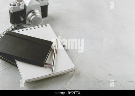 Retro photo Film Kamera mit Hinweis Bücher, Stift auf hellen Hintergrund Stockfoto