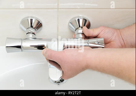 Installieren von Hahn mit Thermostat. Die Hände sind zur Festsetzung Badewanne zu stellen. Stockfoto