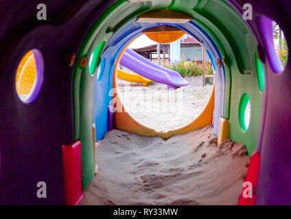 Der weisse Sand am Strand mit dem Spielplatz tunnel Rutschen und Schaukeln in Italien Stockfoto