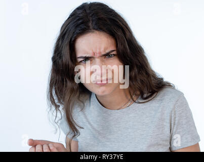 Nahaufnahme, Porträt einer hübschen jungen kaukasischen Mädchen mit einem wütenden Gesicht. Suchen empört und wütend in die Kamera schaut. Menschliche Mimik und em Stockfoto