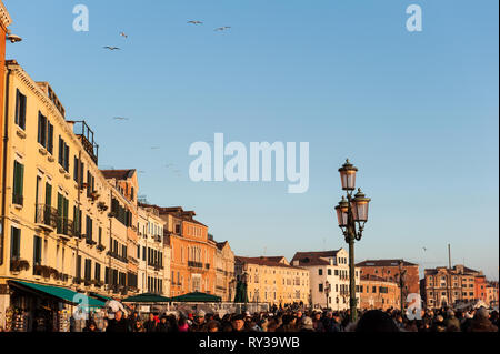 Venedig. Panoramablick im Winter Sonnenuntergang auf der embrachment mit Gebäuden und Personen. Vertikale Ansicht. Stockfoto