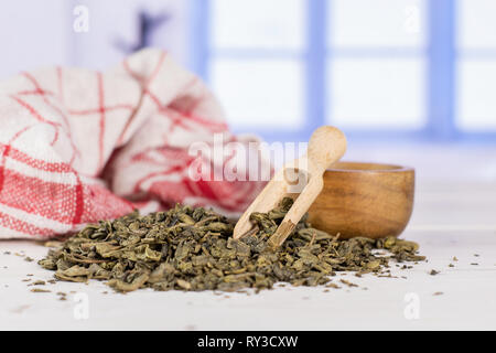 Viele Stücke von trockenen grüner Tee Geschirrtuch mit Holz- Schaufel mit blauen Fenster Stockfoto