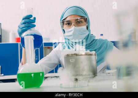 Muslimische Wissenschaftler Kolben während Experiment mit Trockeneis im chemischen Labor Stockfoto