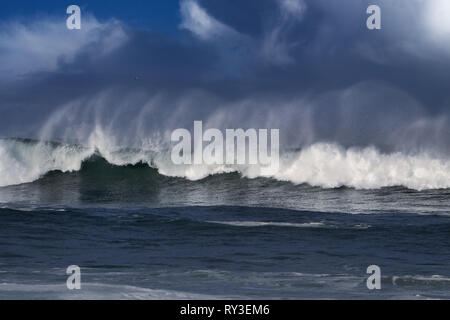 Big Ocean Wave Spray zu sehen, die durch den Wind in die portugiesische Küste; verbesserte Sky Stockfoto