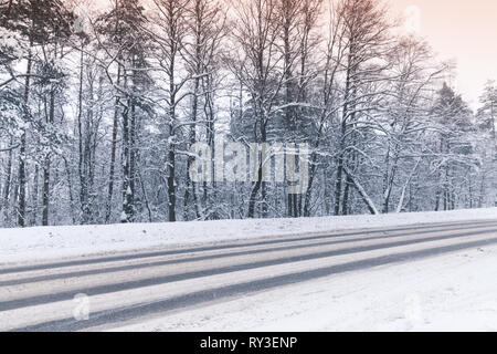Winterlandschaft mit einer leeren Autobahn gehen durch den Wald Stockfoto