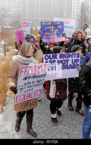 Frauenrechtler marschieren am 19. Januar 2019 mit Schildern in der Innenstadt von Cleveland, Public Square, auf einem kalten Schnee. Stockfoto