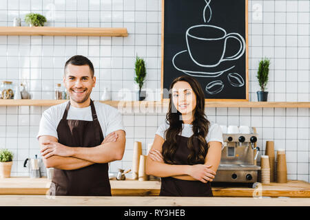 Kassierer hinter hölzernen Tresen und lächelnd in Coffee House Stockfoto