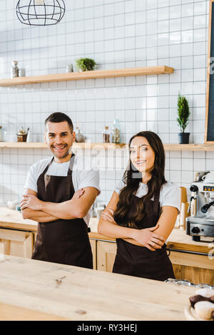 Kassierer und lächelnd hinter Holz- Theke in Coffee House Stockfoto