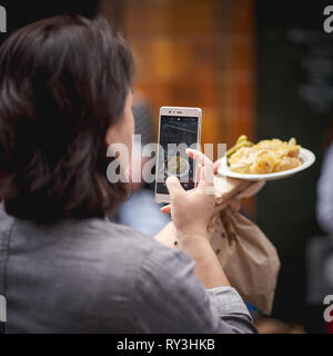 London, UK - August, 2018. Ein Tourist, Foto von Essen in Borough Markt, eine der ältesten und größten Food Market in London. Stockfoto