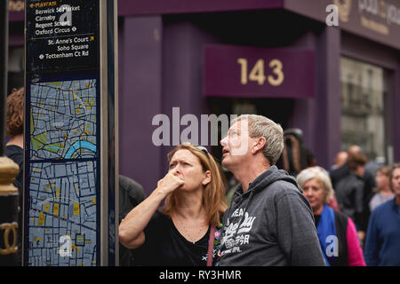 London, UK - August, 2018. Touristen Informationen im Zentrum von London in der Nähe von Soho suchen. Stockfoto