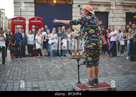 London, UK, September, 2018. Ein strassenkünstler unterhalten, eine Menge von Touristen in Covent Garden. Stockfoto