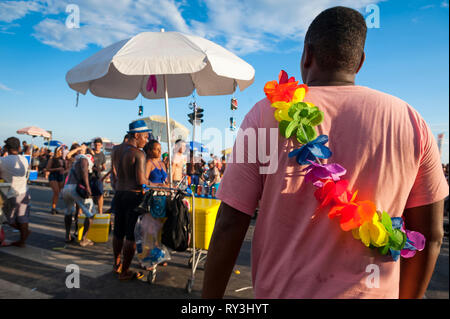 RIO DE JANEIRO - 28. FEBRUAR 2017: ein Mann mit einem regenbogenfarbenen lei Spaziergänge in Karneval Straßenfest in der Farme de Amoedo gay Abschnitt von Ipanema. Stockfoto