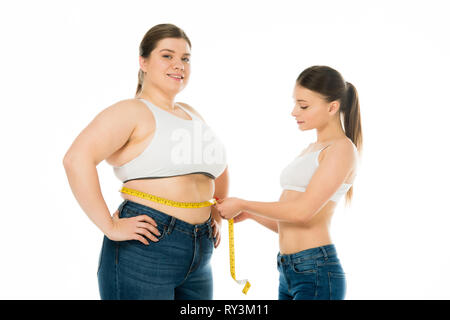 Schlanke Frau messen Taille von Happy übergewichtige Frau auf Weiß, Körper Positivität Konzept isoliert Stockfoto