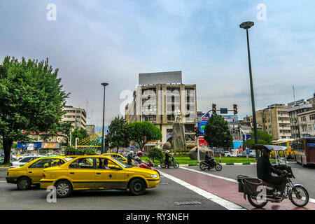 Teheran Ferdowsi Square Statue mit starkem Verkehr Taxi Autos und Motorräder Stockfoto