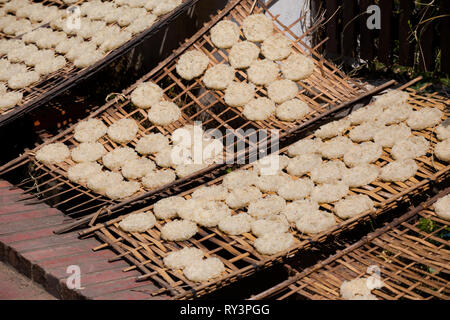 Lao sonnengetrockneten klebriger Reis Kuchen auf Bambus Fächer. Traditionelle laotische Küche aus frischen Zutaten. Stockfoto