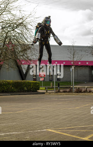 BASINGSTOKE, UK - 11. MÄRZ 2019: Gymnast Ryan Hopgood demonstriert eine Schwerkraft Branchen Jet Pack von Fliegen über den Parkplatz am Basingstoke Freizeitaktivitäten Stockfoto