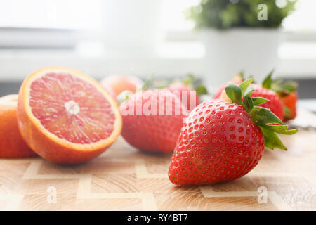 Erdbeere und rot orange am Küchentisch Stockfoto