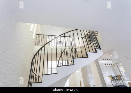 MINSK, Weißrussland - Januar 2019: Wendeltreppe in helle Einrichtung mit weißen Mauer in Elite teure Wohnung Stockfoto