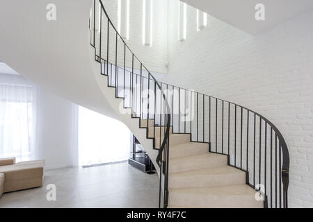 MINSK, Weißrussland - Januar 2019: Wendeltreppe in helle Einrichtung mit weißen Mauer in Elite teure Wohnung Stockfoto