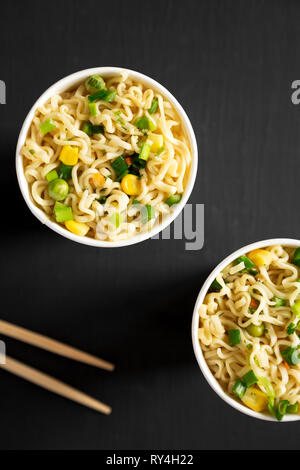 Leckere instant Ramen Nudeln mit Rindfleisch Aroma über schwarzen Oberfläche. Flach, von oben, Overhead. Close-up. Stockfoto