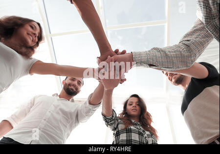 Junge Menschen mit gefalteten Händen zusammen Stockfoto