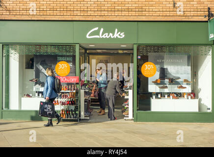 Frauen Shopper Shopping und Suchen im Fenster von Clarks Schuh shop