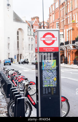 Santander Fahrrad-Dockingstation zusammen mit einer Karte und Zahlungstool auf einer ruhigen Straßenseite. Stockfoto