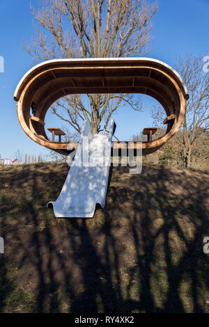 Schöne hölzerne Spielhaus für Kinder mit Rutsche an einem sonnigen Tag Stockfoto